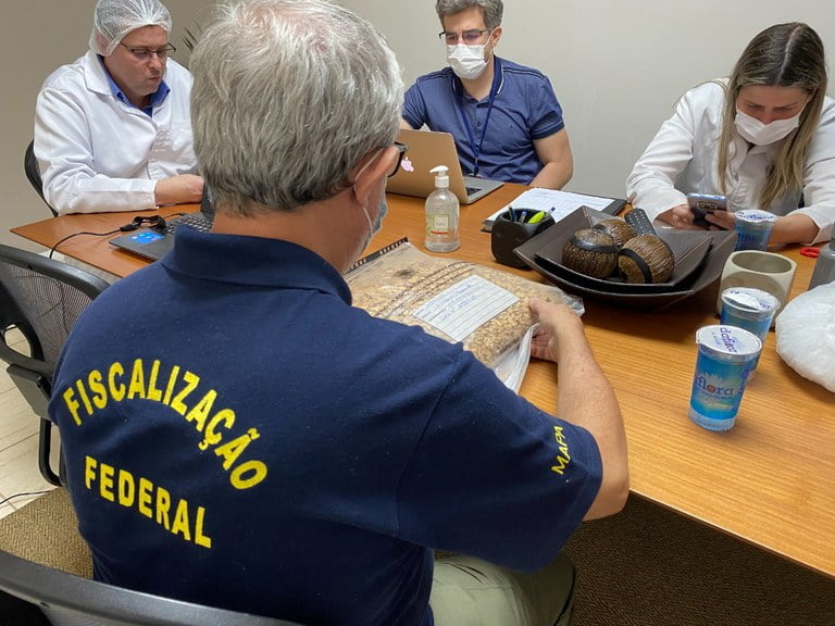 Foto de pessoas em sala de reunião.