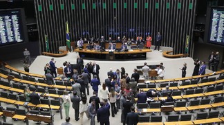 Foto do plenário do Congresso Nacional com políticos sentados à mesa da presidência e os demais em pé na frente do plenário.