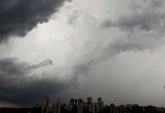 A foto mostra alguns prédios da cidade de São Paulo e nuvens de chuva