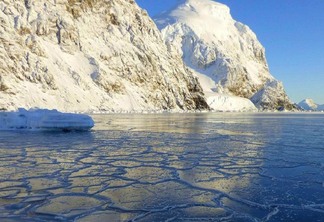A foto mostra uma geleira e o mar congelado