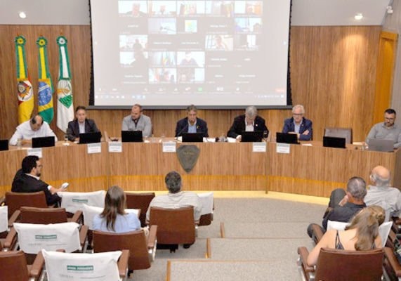 Foto de pessoas em auditório durante reunião.