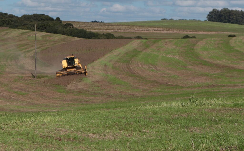 Foto de colheitadeira em área de soja.