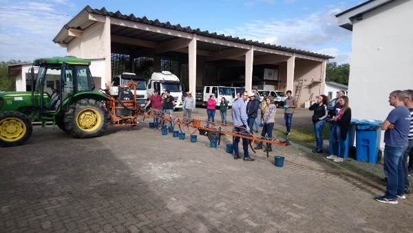 Foto de pessoas ao redor de pulverizador.