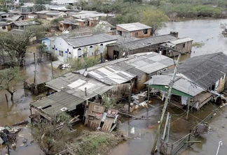 Foto de casas destruídas e rodeadas por água.