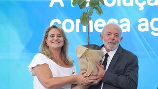 Foto do presidente Lula e da presidente da Embrapa, Silvia Massruhá, segurando uma muda de pequi sem espinhos enquanto posam para foto.