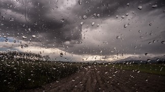 Foto de vista de estrada com céu nublado e gotas de chuva.