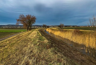 The rural landscape with cloudy blue sky above fields. The rural landscape with cloudy blue sky above fields.