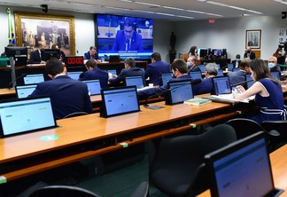 Foto de comissão da Câmara com pessoas sentadas em mesas com um computador. No fundo, está a bancada. Foto de comissão da Câmara com pessoas sentadas em mesas com um computador. No fundo, está a bancada.