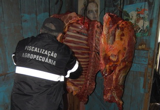 Foto de fiscal agropecuário próximo a cortes de carne. Foto de fiscal agropecuário próximo a cortes de carne.