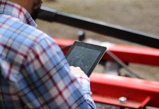 Foto de pessoa com camisa xadrez mexendo em tablet. Foto de pessoa com camisa xadrez mexendo em tablet.