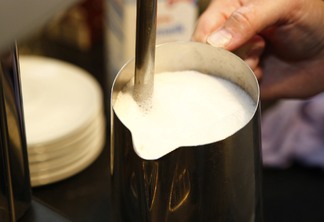 Na foto há uma caneca com leite Na foto há uma caneca com leite