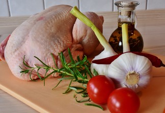 A fotos um frango recheado e alguns temperos A fotos um frango recheado e alguns temperos