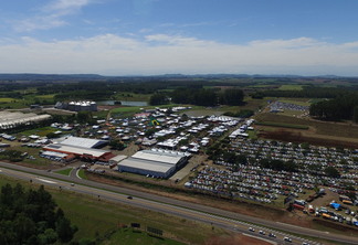 Foto área de evento, com destaque para pavilhões e estacionamentos. Foto área de evento, com destaque para pavilhões e estacionamentos.
