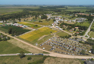 Foto aérea de evento, com estacionamento e estandes a vista.