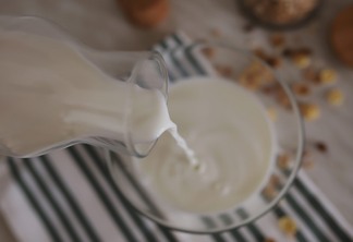 A foto mostra uma jarra despejando leite em uma caçarola