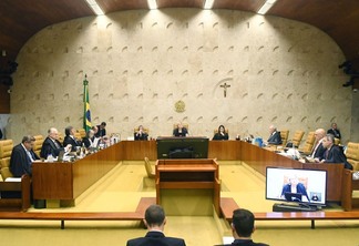 Foto de sessão no Supremo Tribunal Federal . Todos usam preto e no centro estão três mulheres.