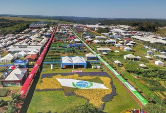 Foto área de feira ao ar livre, com diversos estandes. Ao centro está um jardim que retrata a bandeira do Paraná. Foto área de feira ao ar livre, com diversos estandes. Ao centro está um jardim que retrata a bandeira do Paraná.
