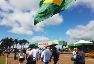 Foto de pessoas caminhando em frente a pórtico da Expodireto Cotrijal. Foto de pessoas caminhando em frente a pórtico da Expodireto Cotrijal.
