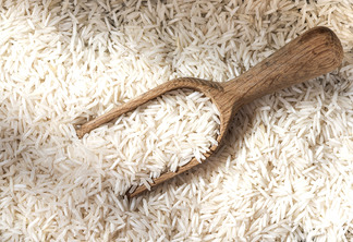 Fundo de grão de arroz branco cru e colher de pau