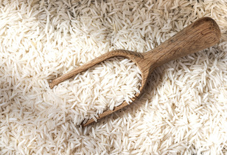 Fundo de grão de arroz branco cru e colher de pau Fundo de grão de arroz branco cru e colher de pau
