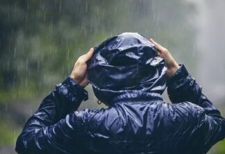 Homem na chuva com casaco preto e capus.