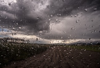 Foto de vista de estrada com céu nublado e gotas de chuva.