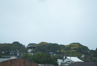 Foto de céu nublado sobre árvores e construções. Foto de céu nublado sobre árvores e construções.