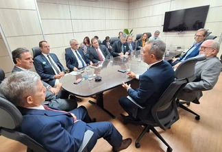 Foto de várias pessoas sentadas ao redor de mesa de reunião. Foto de várias pessoas sentadas ao redor de mesa de reunião.