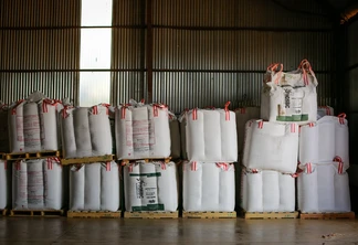 Foto de sacos de fertilizantes empilhados e enfileirados em galpão. Foto de sacos de fertilizantes empilhados e enfileirados em galpão.