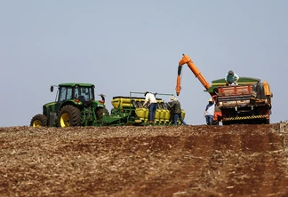 Foto de máquinas e trabalhadores em lavoura preparando a semeadura da soja. Foto de máquinas e trabalhadores em lavoura preparando a semeadura da soja.