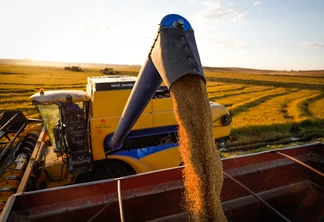 Foto de colheitadeira despejando grãos de arroz em carreta. Foto de colheitadeira despejando grãos de arroz em carreta.