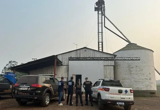 Foto de duas viaturas e quatro agentes em frente a silo. Foto de duas viaturas e quatro agentes em frente a silo.