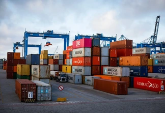 Foto de containers de diferentes cores em porto. Foto de containers de diferentes cores em porto.