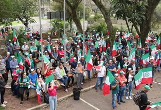 Foto de pessoas reunidas segurando bandeiras da Fetag-RS. Foto de pessoas reunidas segurando bandeiras da Fetag-RS.