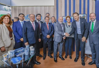 Foto de vários homens e duas mulheres lado a lado sorrindo. O presidente Lula está no centro e cumprimenta um dos homens. Foto de vários homens e duas mulheres lado a lado sorrindo. O presidente Lula está no centro e cumprimenta um dos homens.