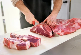 Foto pessoa cortando carne em bancada branca. Foto pessoa cortando carne em bancada branca.