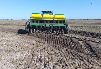 Foto de máquina realizando a semeadura do arroz. Foto de máquina realizando a semeadura do arroz.