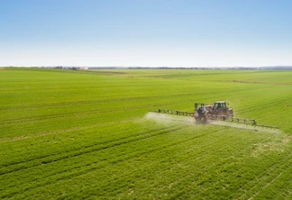 Foto de trator realizando pulverização em lavoura. Foto de trator realizando pulverização em lavoura.