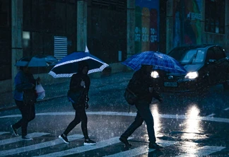 Pedestres passando pela faixa de pedestres na chuva. Pedestres passando pela faixa de pedestres na chuva.