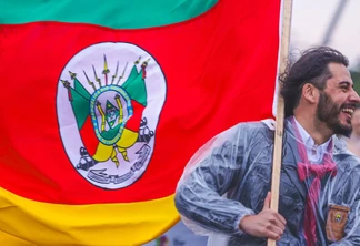 Foto de um homem segurando a bandeira do Rio Grande do Sul. Foto de um homem segurando a bandeira do Rio Grande do Sul.