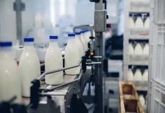 Garrafas com leite, em uma máquina de fábrica