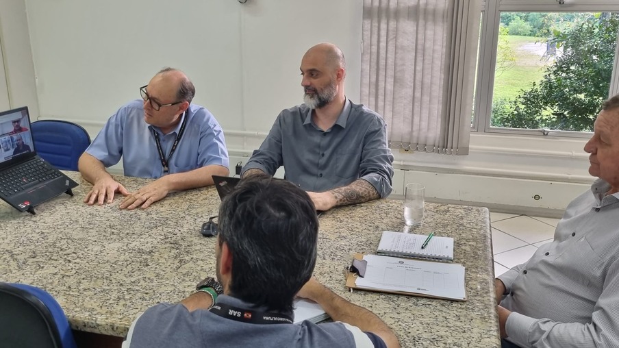 Homens conversando sentados em uma mesa Homens conversando sentados em uma mesa