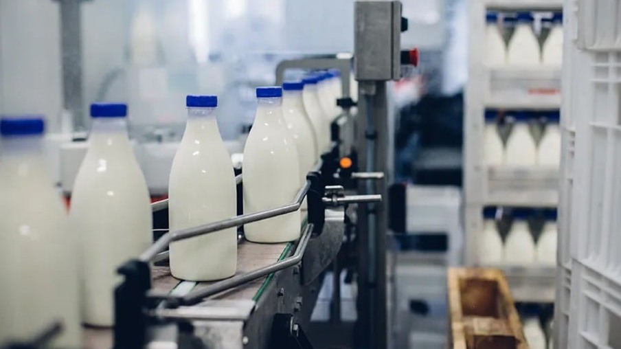 Garrafas com leite, em uma máquina de fábrica