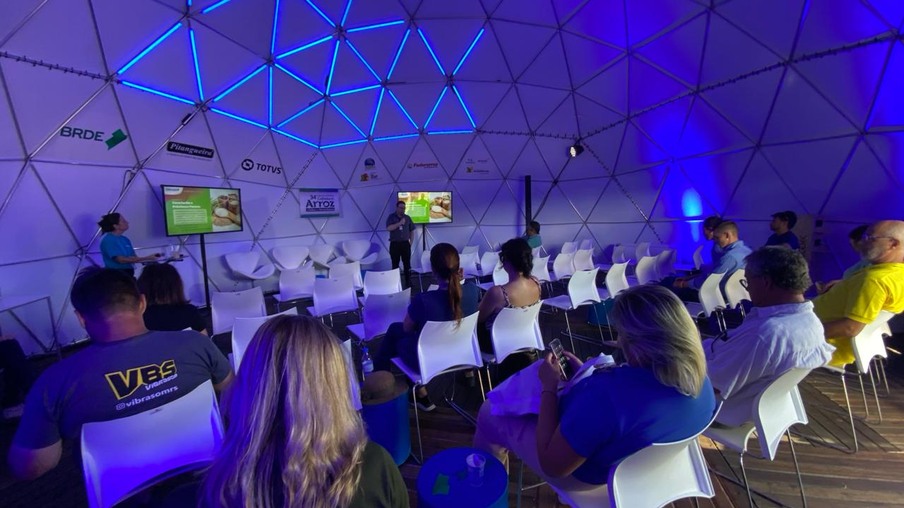 Pessoas assistindo um homem palestrar Pessoas assistindo um homem palestrar