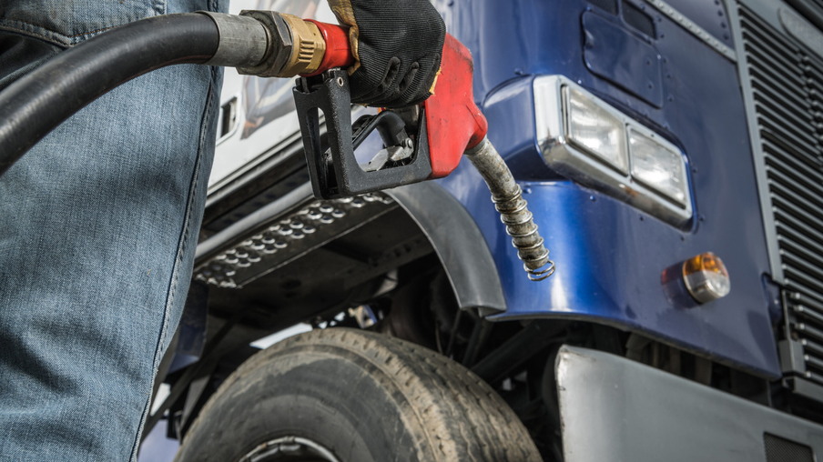 Caminhoneiro na frente de seu caminhão se preparando para o abastecimento de diesel. Caminhoneiro na frente de seu caminhão se preparando para o abastecimento de diesel.