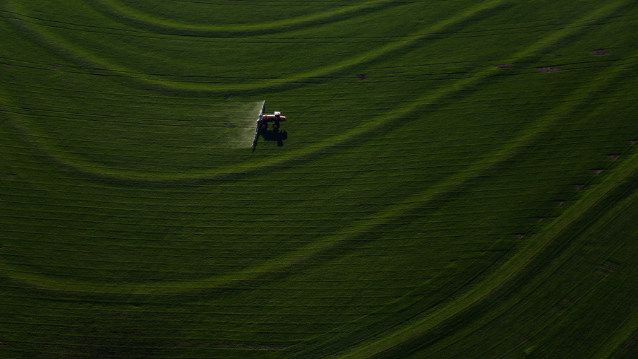 Máquina agrícola realizando tratamento em lavoura. Máquina agrícola realizando tratamento em lavoura.
