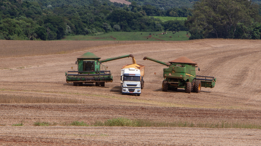 Colheitadeiras descarregando soja em caminhão Colheitadeiras descarregando soja em caminhão