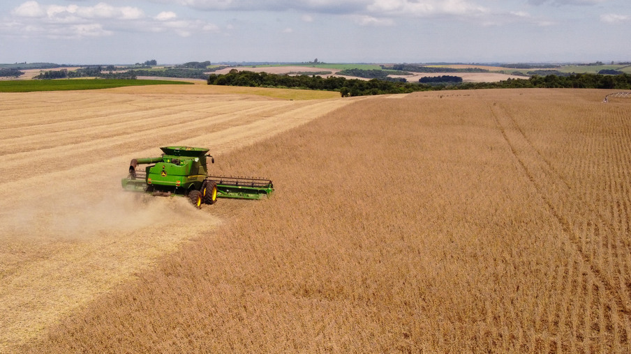 Colheitadeira em operação na lavoura de soja Colheitadeira em operação na lavoura de soja