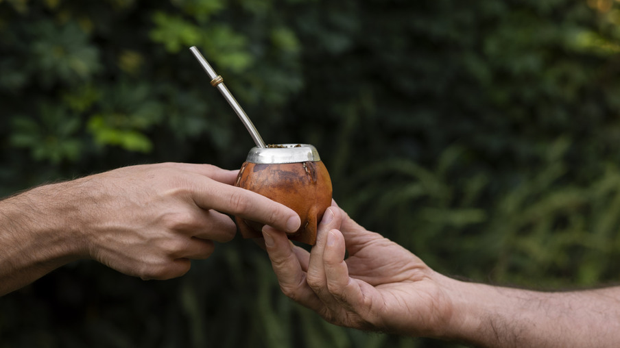 Foto de mãos passando cuia de chimarrão. Foto de mãos passando cuia de chimarrão.