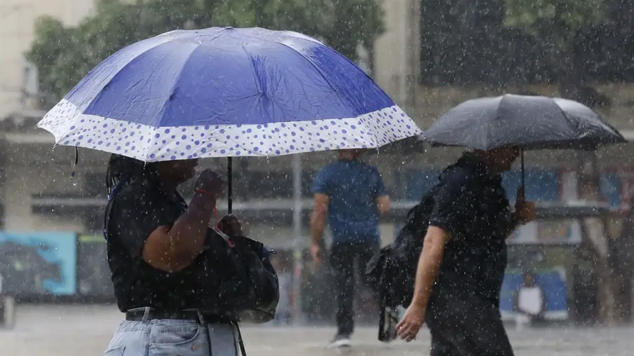 Foto de mulher e homem segurando guarda-chuva durante chuva. Foto de mulher e homem segurando guarda-chuva durante chuva.